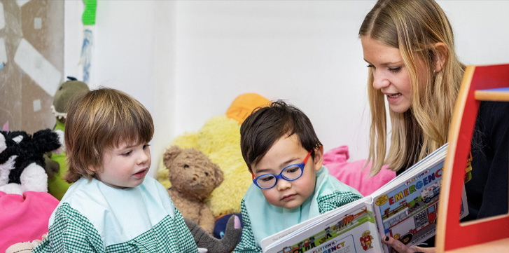 2 kids reading a picture book