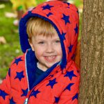 smiling child wearing a red and blue star coat