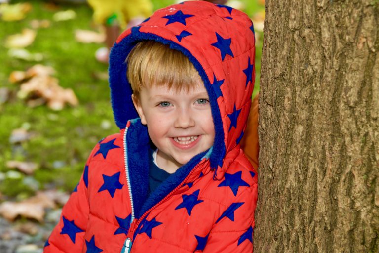 smiling child wearing a red and blue star coat