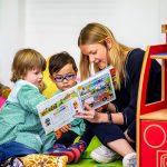 children reading a book together