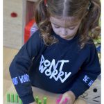 young girl playing with a wooden puzzle game