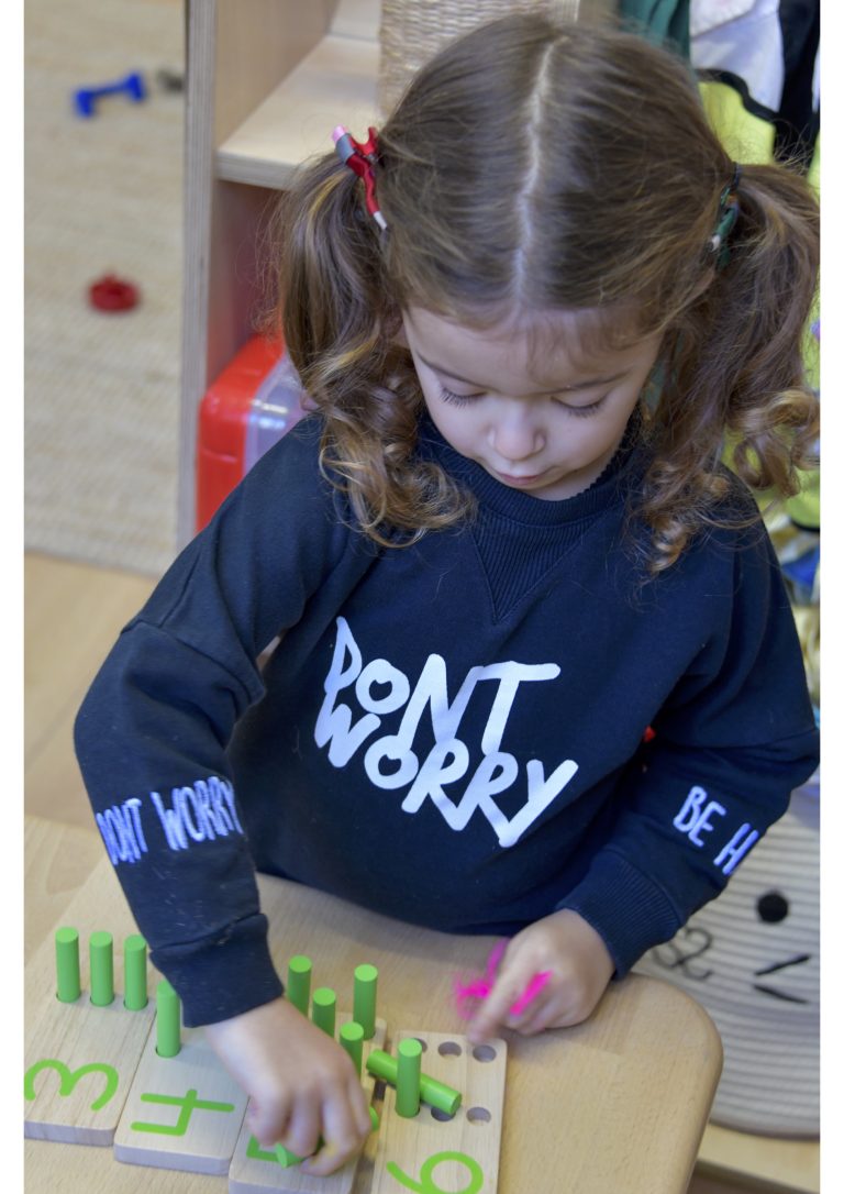 young girl playing with a wooden puzzle game