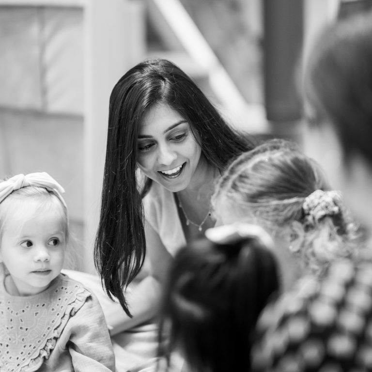 black and white photo of lady smiling next to little kids