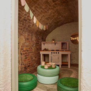 a bricked room with green seating area