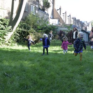 children running on a field with teacher supervision