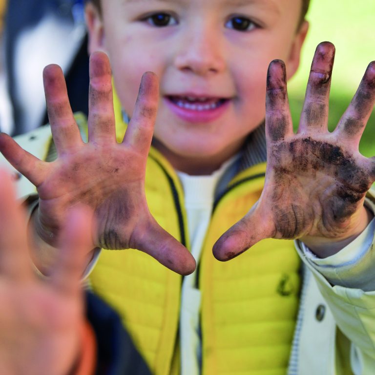 little boy with muddy hands